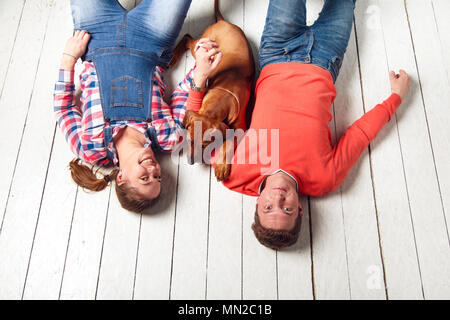 Junges Paar spielen mit ihren Welpen. Das Konzept einer glücklichen Familie leben. Stockfoto