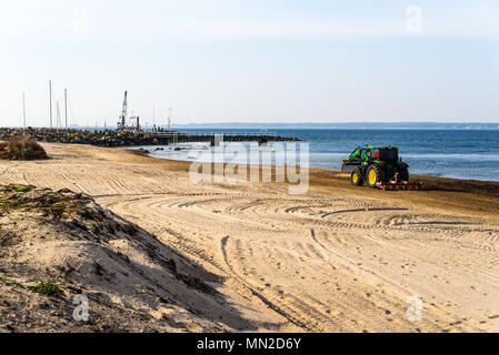 Corfu, Schweden - 30 April, 2018: Dokumentation des täglichen Lebens und. Grün John Deere 6120 Traktor Reinigung Algen und Steine vom Strand Stockfoto