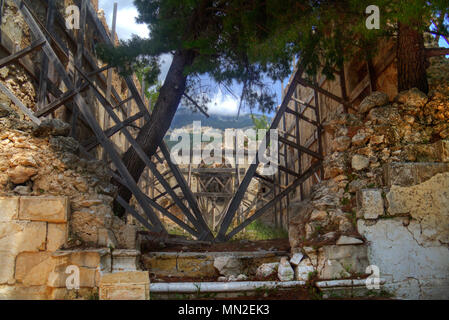 Die antike Ruine des Klosters Sisia auf Kefalonia, stark durch das Erdbeben 1953 beschädigt, kaum zusammenzuhalten, Holz- streben. Stockfoto