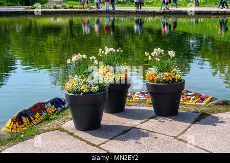 Britzer Garten, Neukölln, Berlin, Deutschland. 2018. Gartenblick, Topf plats und farbige Felsen außerhalb Cafe am Sehen und Menschen zu Fuß am See in Sp Stockfoto