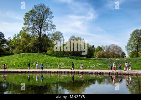 Britzer Garten, Neukölln, Berlin, Deutschland. 2018. Garten Landschaft sehen. Menschen gehen nächsten See zu ruhigen, Frühling Blumen, Bäume und blauer Himmel im Frühjahr Stockfoto