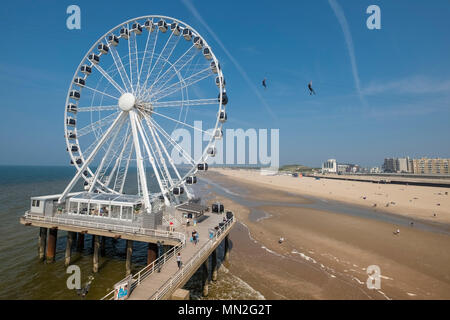 Riesenrad auf Scheveningen Seebrücke und Strand, mit 2 Leuten auf Drahtseil im Hintergrund, Wassenaar Bezirk, Den Haag (Den Haag), Niederlande Stockfoto