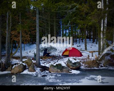 Wilde wald winter Camp mit Zelt vor der gefrorenen See in Schweden. Stockfoto