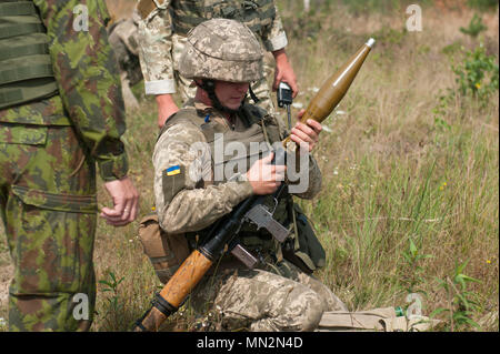 Eine litauische Mentor fungiert als Sicherheit, während ein Soldat aus der Ukraine 1st Battalion, 95th Separate Airmobile Brigade bereitet eine Rakete abzufeuern - selbstfahrende Granate während der Kombinierten montiert und demontiert Bewegung Techniken Ausbildung an der Yavoriv Combat Training Center auf dem internationalen Friedens und der Sicherheit in der Nähe von Yavoriv, Ukraine am 12.08.21. Yavoriv CTC Beobachter Trainer Trainer, zusammen mit den Mentoren aus Litauen und der US Army 45th Infantry Brigade Combat Team, die Ausbildung zum Soldaten führten ab dem 1.Bataillon, 95 separaten Airmobile Brigade während der Drehung des Bataillon Stockfoto