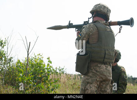 Eine litauische Mentor fungiert als Sicherheit, während ein Soldat aus der Ukraine 1st Battalion, 95th Separate Airmobile Brigade bereitet eine Rakete abzufeuern - selbstfahrende Granate während der Kombinierten montiert und demontiert Bewegung Techniken Ausbildung an der Yavoriv Combat Training Center auf dem internationalen Friedens und der Sicherheit in der Nähe von Yavoriv, Ukraine am 12.08.21. Yavoriv CTC Beobachter Trainer Trainer, zusammen mit den Mentoren aus Litauen und der US Army 45th Infantry Brigade Combat Team, die Ausbildung zum Soldaten führten ab dem 1.Bataillon, 95 separaten Airmobile Brigade während der Drehung des Bataillon Stockfoto