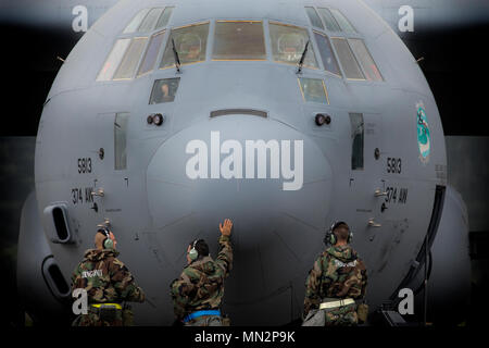 Mannschaft Leiter aus der 374 Aircraft Maintenance Squadron erwarten eine C-130J Super Hercules Motor während der Übung Beverly Morgen 17-05 bei Yokota Air Base, Japan, August 18, 2017 zu starten. Die Ausbildung ist so konzipiert, dass die Fähigkeit der Flieger in kargen Umgebungen mit chemischen zu überleben zu testen, biologische, radiologische, nukleare und explosive Gefahren. (U.S. Air Force Foto von Yasuo Osakabe) Stockfoto