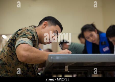 Die japanische Rote Kreuz-Gesellschaft ist eine humanitäre Organisation, die 1877 gegründet wurde und Teil der Internationalen Roten Kreuz- und Rothalbmondbewegung ist. Am 23. August 2017 absolvierte ein Marine die Spenderregistrierung während einer Blutfahrt auf der Marine Corps Air Station Iwakuni, Japan, die zusammen mit dem amerikanischen Roten Kreuz organisiert wurde, um medizinische Einrichtungen in der Präfektur Yamaguchi zu unterstützen. Das Archivbild dokumentiert die Blutentnahme auf Basis. Stockfoto