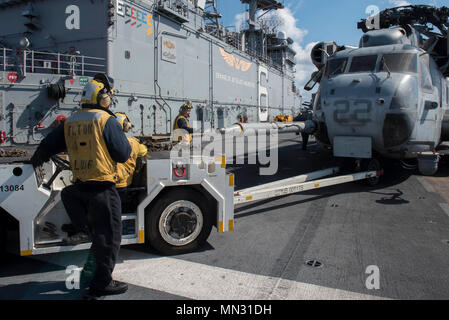 170825-N-NB 544-071 CORAL SEA (Aug. 25, 2017) der Luftfahrt Bootsmann Gehilfen (Handling) verwenden Sie ein ALS 32/A-39 an Bord Schlepper ein CH-53E Super Stallion, zugeordnet zu den 'Dragons" der Marine Medium Tiltrotor Squadron (VMM) 265 (Verstärkt) zu bewegen, auf dem Flugdeck des Amphibious Assault ship USS BONHOMME RICHARD (LHD6). Bonhomme Richard, dem Flaggschiff der Bonhomme Richard Expeditionary Strike Group, ist die in der pazifischen Region Indo-Asia Partnerschaften zu verbessern und eine fertige Antwort für jede Art von Kontingenz. (U.S. Marine Foto von Mass Communication Specialist 2. Klasse Kyle Carlstr Stockfoto