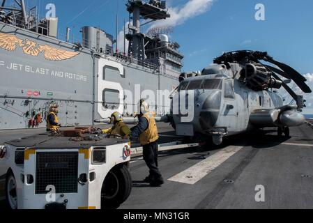 170825-N-NB 544-092 CORAL SEA (Aug. 25, 2017) der Luftfahrt Bootsmann Gehilfen (Handling) verwenden Sie ein ALS 32/A-39 an Bord Schlepper ein CH-53E Super Stallion, zugeordnet zu den 'Dragons" der Marine Medium Tiltrotor Squadron (VMM) 265 (Verstärkt) zu bewegen, auf dem Flugdeck des Amphibious Assault ship USS BONHOMME RICHARD (LHD6). Bonhomme Richard, dem Flaggschiff der Bonhomme Richard Expeditionary Strike Group, ist die in der pazifischen Region Indo-Asia Partnerschaften zu verbessern und eine fertige Antwort für jede Art von Kontingenz. (U.S. Marine Foto von Mass Communication Specialist 2. Klasse Kyle Carlstr Stockfoto