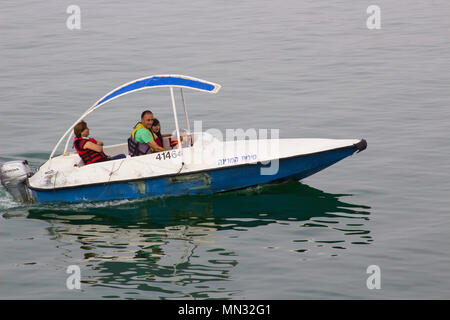 Einer lokalen Familie und genießen Sie Ihre kleinen Boot auf dem ruhigen Wasser des Sees von Galiläa in Tiberias Israel in den frühen Abend auf ein DUNSTIGER Tag im Mai 2018 Stockfoto