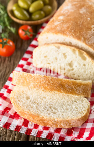 Frische italienische Ciabatta Brot in Scheiben, Tomaten und grüne Oliven auf der Seite (selektive Fokus) Stockfoto