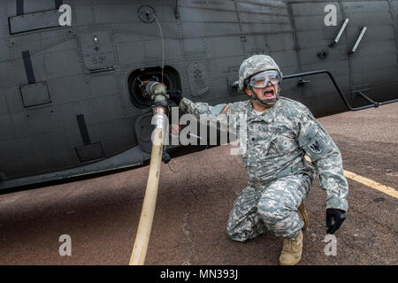 Spc. Nicolas Lopez aus Tomball, Texas, eine US-Armee-reservesoldat mit E Firma, 1-158, 11 Expeditionary Combat Aviation Brigade, schreit beim Tanken ein UH-60 Black Hawk Hubschrauber in Dallas, Texas, 30. August 2017. Lopez und seine Distanziertheit in Conroe für die letzten drei Tage wurde der 11 ECAB in Such- und Rettungseinsätze während des Hurrikans Harvey zu unterstützen. (U.S. Armee finden Foto: Staff Sgt. Felix R. Fimbres) Stockfoto