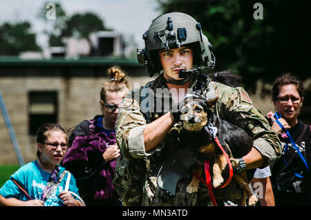 Senior Airman Austin Hellweg, 129 Rescue Squadron spezielle Missionen aviator, trägt ein Hund und führt eine Familie in ein HH-60 Pavehawk für die Extraktion zu einem sichereren Ort während der Entlastung Bemühung für Hurrikan Harvey, Aug 31st, 2017, Beaumont, Texas. Die Hilfsaktionen haben ein Konglomerat von aktiven Schutzes und der Reserve Einheiten aus allen Zweigen der Bundesregierung zu helfen, Texas vom Hurrikan Harvey erholen. (U.S. Air Force Foto: Staff Sgt. Jordan Castelan) Stockfoto