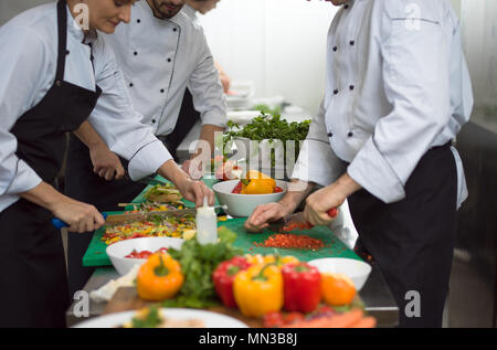 Professionelles team Köchinnen und Köche Vorbereiten der Mahlzeiten an belebten Hotel oder Restaurant Küche Stockfoto