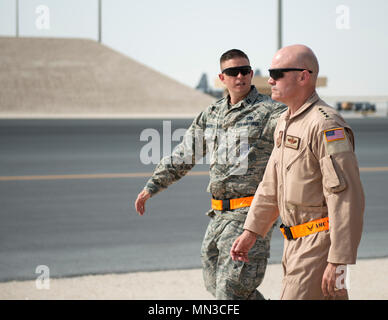 Us-Luftwaffe Kapitän Travis Mongeon, Maintenance Operations Officer mit der 8 Expeditionary Air Mobility Squadron, Links, Escorts Gen. Carlton D. Everhart II, Commander Air Mobility Command, zu seinem nächsten Lage im Al Udeid Air Base, Katar, 12.08.16, 2017. Everhart wurde von Chief Master Sgt. Shelina Frey, Befehl chief AMC und machte mehrere Haltestellen innerhalb der 8 EAMS Abschnitte, eine Chance für Flieger über ihre Pflichten zu sprechen und Fragen zu stellen. (U.S. Air Force Foto von Tech. Sgt. Amy M. Lovgren) Stockfoto