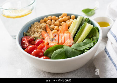 Salatschüssel mit Quinoa, Kichererbsen, Gurken, Karotten, Spinat und Tomaten. Konzept der gesunden Ernährung, gesunde Lebensweise, Ernährung, vegan und v Stockfoto