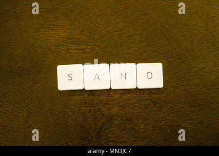 SAND Wort auf Kunststoff Tastatur Alphabet mit dunklem Hintergrund geschrieben Stockfoto