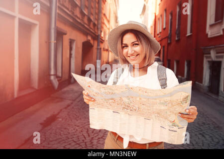 Reiseführer. Junge weibliche Reisende mit Rucksack und mit Karte auf die Straße. Travel Concept. Abenteuer Stockfoto