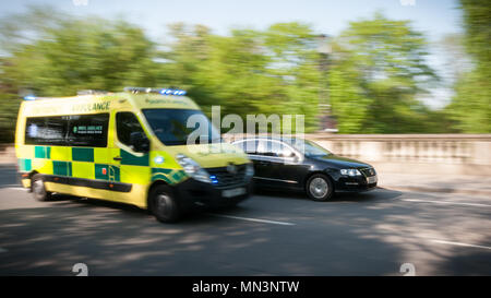 Rettungswagen überholen ein Auto im Verkehr Stockfoto