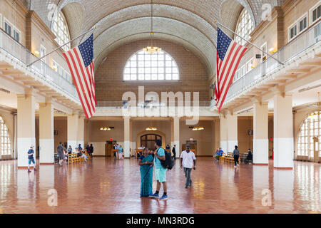 Touristen, die sich in der Großen Halle, Ellis Island Immigration Museum, Ellis Island, New York City, USA Stockfoto