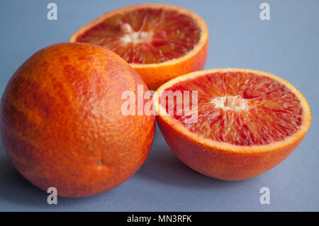 Zwei Hälften ein vollblut Orange auf lila Hintergrund. Stockfoto