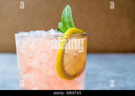 Rosa Cocktail mit Crushed Eis, Minze und Zitrone. Beverage Konzept. Stockfoto