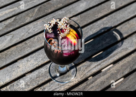 Sangria Cocktail in Wein Glas mit Zitrone, Zimt, Obst und Eis. Beverage Konzept. Stockfoto