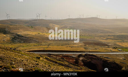 Wüste Straße Autobahn mit Windmühle auf dem Hintergrund in einem wüstenklima Landschaft Stockfoto