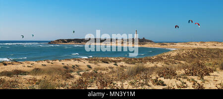 Panoramablick mit vielen Menschen Kitesurfen am Strand von Los Caños de Meca, neben dem Leuchtturm von Trafalgar, an der Küste von Cadiz, S Stockfoto