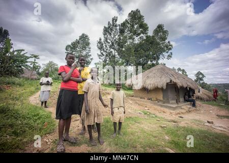 Paidha, Uganda. 5 Mai, 2018. Lokale Dorfbewohner für ein Foto vor ihren traditionellen Stil zu Hause posieren. Landwirtschaft mehr als 95% des Einkommens für die Dorfbewohner, die sich in den Dörfern in der Nähe der Stadt Paidha im Nordwesten Ugandas nahe der Grenze zur Demokratischen Republik Kongo leben. Aus all den Landwirtschaft Produkte Kaffee machen mehr als 60 % ihres Gesamteinkommens, den aktuellen Preis für Kaffee ist 5000 Schilling (1,30 USD) $ pro kg, während andere Produkte wie Avocados und Labyrinth im Wert sogar noch weniger. Über 90 % der lokalen Familien leben ohne Elektrizität, und Dorfbewohner o Stockfoto