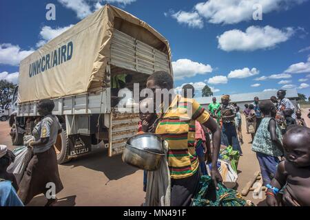 Kuluba, Uganda. 8. Mai, 2018. Eine der Südsudanesische single Mutter ihr Baby tragen, wie sie in der Kuluba Refugee reception centre in Grenzregion zwischen Sudan und Uganda am 8. Mai 2018 eingegangen ist. Sie war immer noch in Ihre 2 Metallbehälter, die sie für sich und ihr Baby zu füttern, während Sie in den Wald im Süden des Sudan versteckt hatte, bevor er eine Chance in Uganda verwendet. Die Kuluba refugee Reception Centre ist eines von vielen Zentren in Norduganda speziell gebaut, die Hunderttausende von Süden sudanesische Flüchtlinge Zustrom zu behandeln. Die Rezeption ist Stockfoto