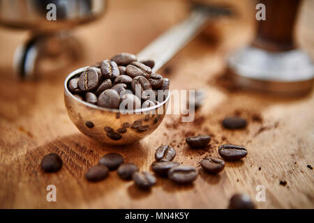 Close up geröstete Kaffeebohnen in Messbecher Schaufel Stockfoto