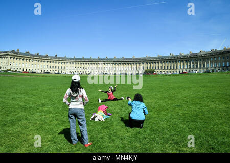 Touristen nehmen Sie Fotos von sich selbst auf dem Rasen vor der Badewanne Royal Crescent, wo sonniges Wetter und Temperaturen im hohen Teens über Teile der South West bestehen. Stockfoto