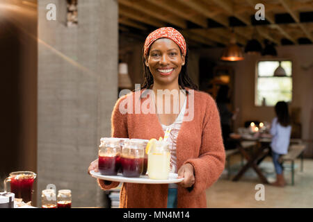 Porträt Lächeln, selbstbewusste Frau mit Limonade und Sangria Stockfoto