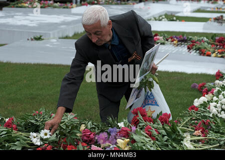 Ein Mann Blumen Verlegung in das Gedächtnis der Herrlichkeit, die die Veteranen und die Toten des Zweiten Weltkrieges gedenkt, die Soviet-Afghan Krieg und die 1990-1992 Transnistrien Krieg auf Suvorov Square in Tiraspol die Hauptstadt und das Verwaltungszentrum der international anerkannten Grenzen der Republik Moldau unter der De-facto-Kontrolle der nicht anerkannten Moldawischen Republik Transnistrien Pridnestrovian (PMR) seit 1992 genannt. Stockfoto