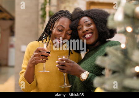 Portrait lächelnd, glücklich, Mutter und Tochter umarmen, das Trinken von Wein Stockfoto