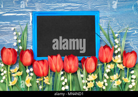 Tafel mit roten Tulpen und Maiglöckchen Blumen auf blau im Hintergrund. Platz für Ihre test, Flach, straff Bild. Stockfoto