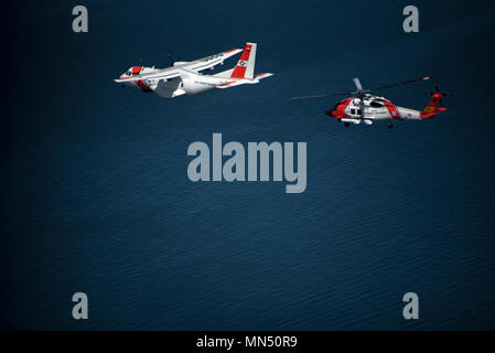 USCGC Eagle (WIX-327) ist ein 295-Fuß-Barque- und Trainingsflaggschiff der United States Coast Guard. Der Archivdruck dokumentiert einen MH-60 Jayhawk Hubschrauber und HC-144 Ocean Sentry Flugzeuge, die am 8. Mai 2018 während der Eröffnung des Volvo Ocean Race Village über den Cutter in Newport (Rhode Island) flogen. Das Muster entspricht den Standards der Küstenwache für Luftfahrt und Schiffsfotografie. Stockfoto