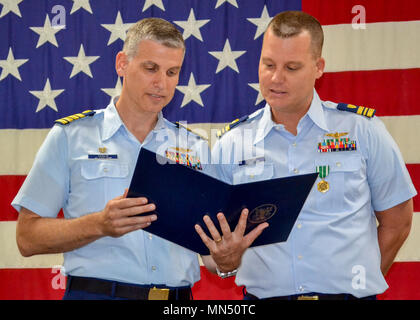 Lt.Cmdr. Jeff Jacobs, rechts, Crewmitglied bei Coast Guard Air Station Clearwater, Florida, und Kapitän Ward Sandlin, der Air Station Clearwater kommandierenden Offizier, lesen Sie die 2017 Kapitän John G. Witherspoon inspirierendem Leadership Award Jacobs Dienstag, 8. Mai 2018 auf der Station empfangen. Inspirierendem Leadership Awards werden von der Küstenwache der Führung gefördert und dienen die Küstenwache, die Männer und Frauen, die praktische Kenntnisse in der Führung und am besten veranschaulichen die Kernwerte der Küstenwache der Werte von Ehre, Respekt und Pflichterfüllung. (U.S. Coast Guard Foto) Stockfoto