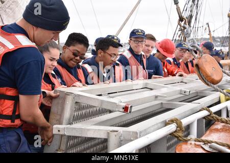 Coast Guard Cutter Eagle Crewmitglieder und neue London High School ROTC Studenten arbeiten zusammen, um eine Braue an Bord der Cutter Mai 10, 2018 zu sichern. Die Fräse über unterwegs nach New London, Connecticut mit Mitgliedern der Coast Guard Foundation, Coast Guard Academy, New London Rotary Club und Studierende in das neue London High School Navy ROTC. Coast Guard Foto von Petty Officer 3. Klasse Brandon Murray. Stockfoto