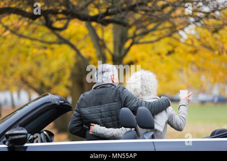 Senior Paar mit Cabrio im Herbst Park Stockfoto