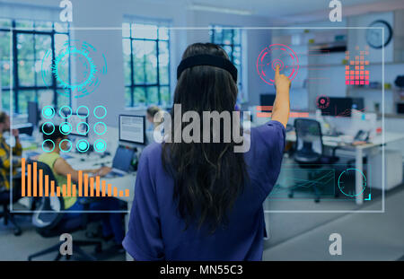 Geschäftsfrau mit futuristischen Hologramm Computer im Büro Stockfoto