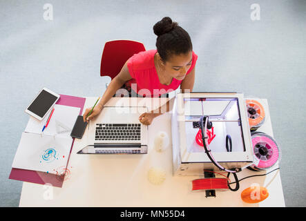 Weibliche Designer bei Laptop während der 3D-Drucker Stockfoto