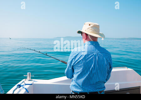 Ein Mann die Fischerei Ende einer kleinen Yacht, Großbritannien Stockfoto