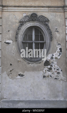 Runde Fenster der Kirche Leichenhalle mit Totenkopf und Flügel auf der Oberseite. Vertikale erschossen. Stockfoto