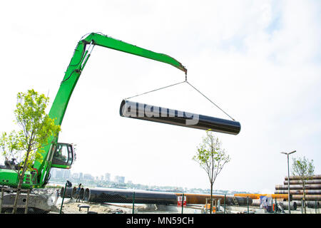 Laden von Stahlerzeugnissen und Wasserleitungen mit einem Lagerbereich in speziellen Kran. Stockfoto