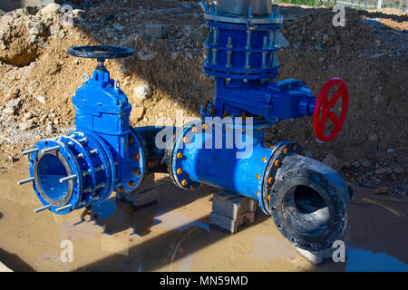 Bau der Wasserversorgung der Stadt Pipeline. 500 mm große Wasserleitung mit Schieber, 250 mm Zweig. Leitungen verbunden mit neuen blauen Schieber und Stockfoto