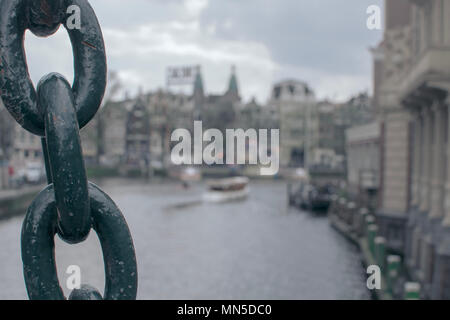 Blick auf den Kanal von Amsterdam City hinter einer großen Kette Stockfoto