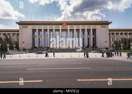 Peking, China - 27. April 2010: Große Halle des Volkes auf dem Platz des Himmlischen Friedens unter blauem Himmel mit grauen Wolken. Menschen und Autos in weite Einstellung. Stockfoto
