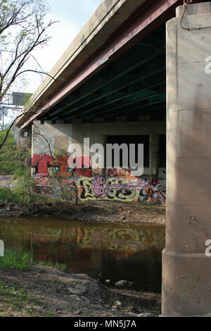 Graffiti unter der Brücke entlang des Flusses gefunden. Stockfoto